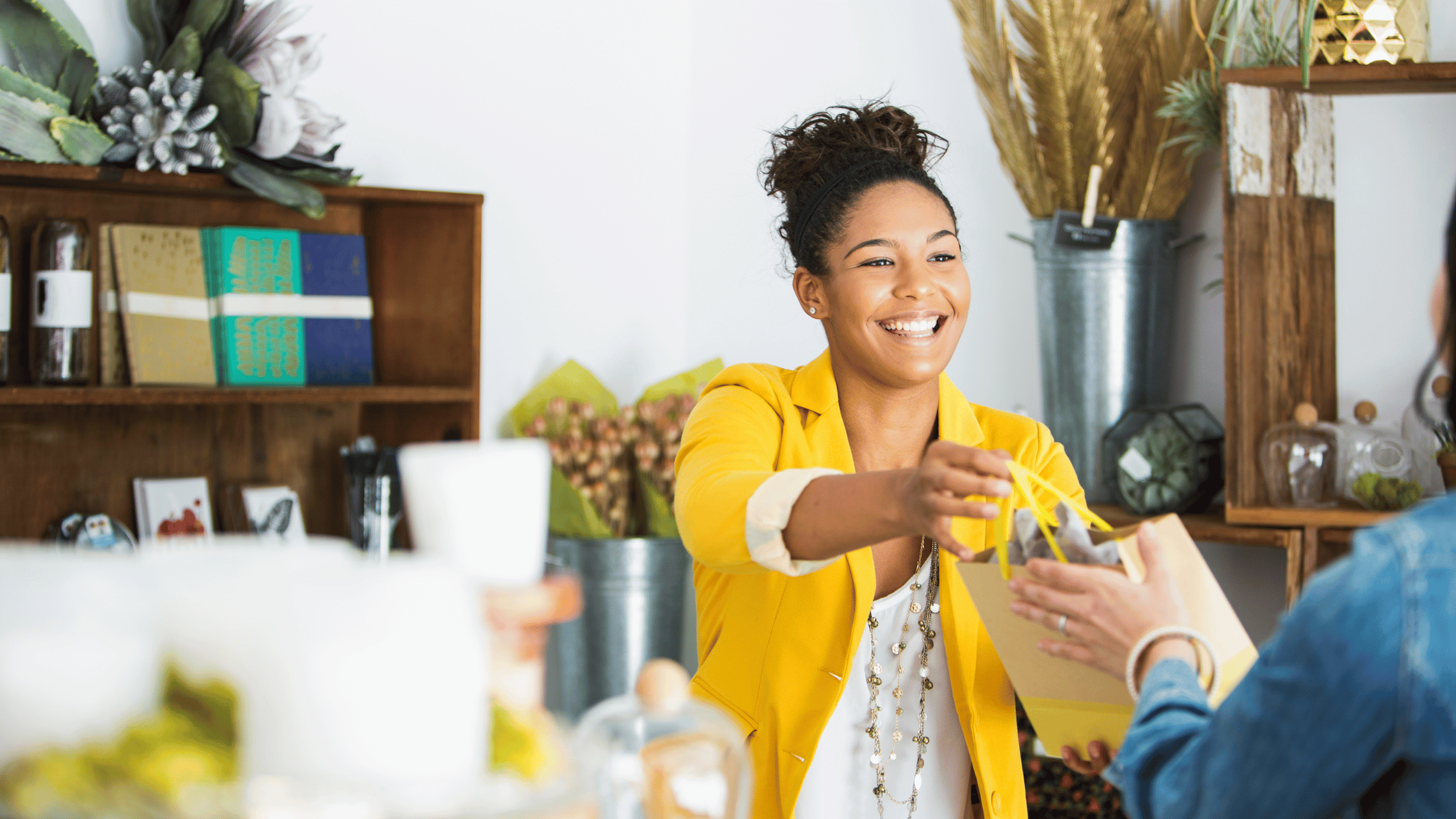 Woman handing a purchase to a customer